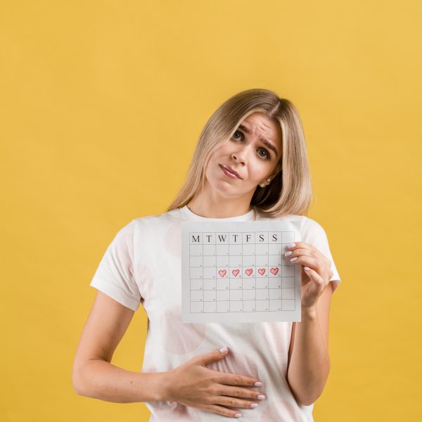 female-puts-hand-abdomen-showing-period-calendar